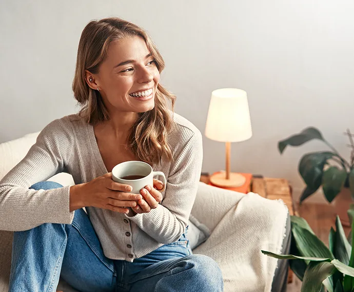 Cliente de CreaEnergia relajada en casa con luz barata online, energía 100% verde y sin letra pequeña.